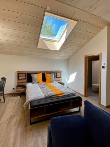 a bedroom with a bed and a skylight at Le Cras in Soubey