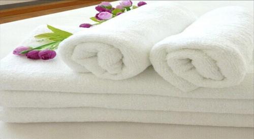 a stack of towels with flowers on a bed at Albergo Ristorante Il Laghetto in Fiumalbo