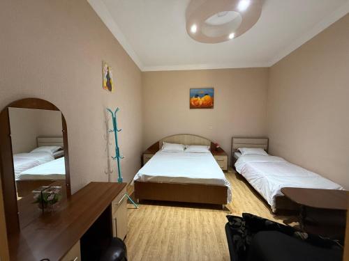 a bedroom with two beds and a mirror at Nato & Lado in Sighnaghi