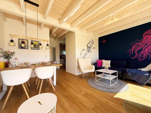 a living room with a blue couch and white chairs at Ferienhaus Fischkopf mit Sauna und Strandkorb in Büsum