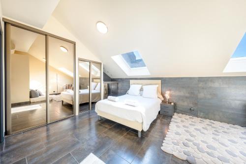 a bedroom with a white bed and a bathroom at Le Princess in Évian-les-Bains