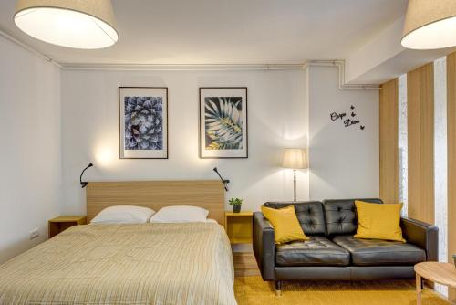 a bedroom with a bed and a couch at Bucharest Airport Suites & Villas in Otopeni