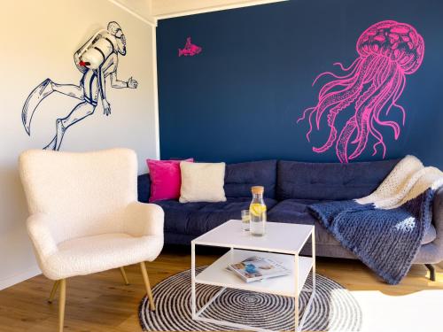 a living room with a blue couch and an octopus on the wall at Ferienhaus Fischkopf mit Sauna und Strandkorb in Büsum