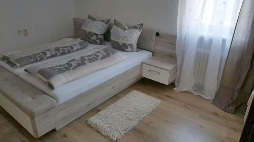 a bedroom with a large white bed with a rug at Pension Hofer in Bad Berneck im Fichtelgebirge