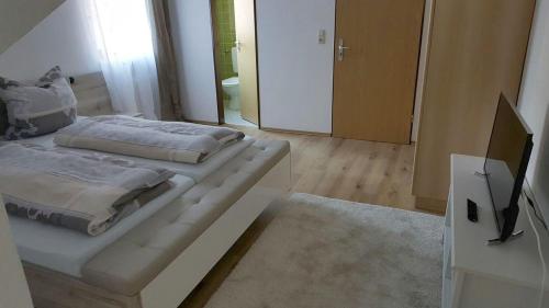 a bedroom with two beds and a flat screen tv at Pension Hofer in Bad Berneck im Fichtelgebirge