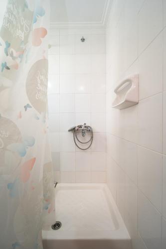 a white bathroom with a shower with a toilet at Nisaki Summer Stay Studios in Agia Ermioni