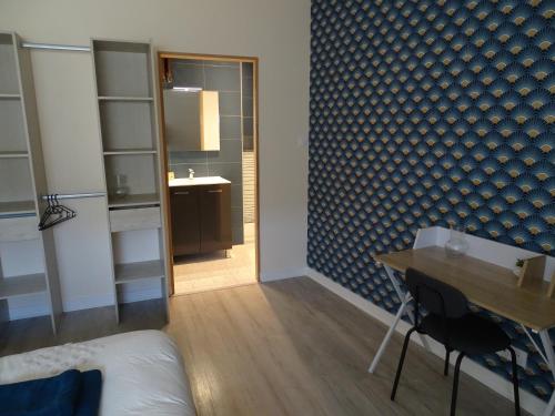 a room with a table and a bathroom with a mirror at Bryce Canyon in Châteaubourg