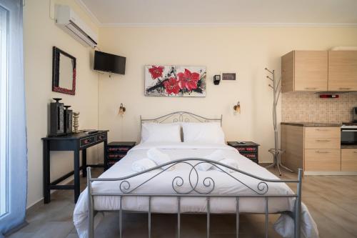 a bedroom with a bed and a desk in a room at Nisaki Summer Stay Studios in Agia Ermioni