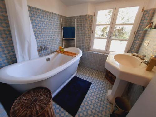 a bathroom with a large tub and a sink at Le mas des louquiers in Mons