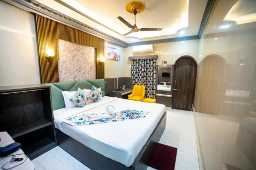a bedroom with a large bed and a yellow chair at Hotel Priyadarshini in Digha