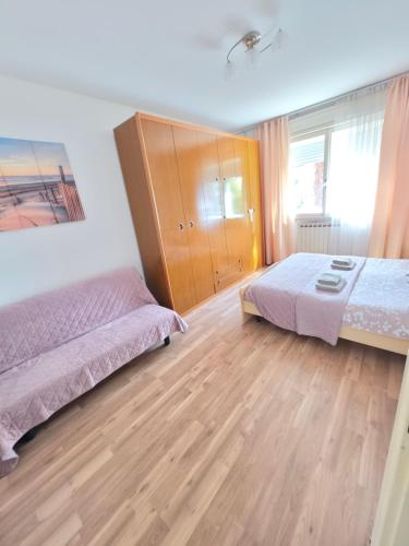 a bedroom with two beds and a wooden cabinet at Appartamento Silva in Gorizia