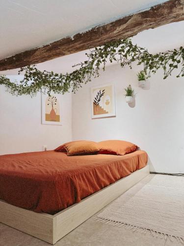 a bedroom with a bed with plants on the wall at Escapade bohème in Bergerac
