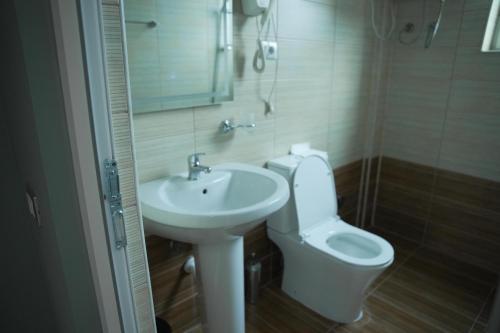 a bathroom with a white toilet and a sink at Hotel haliti kukes in Kukës