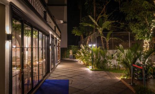 a walkway outside of a building at night at Goan Bliss Alaya Stays by ELIVAAS in Varca