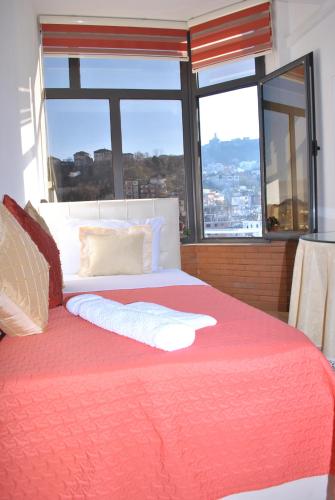 um quarto com uma cama grande e uma janela grande em Hotel The First em Gjirokastër