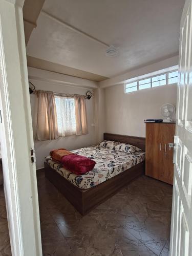 a bedroom with a bed and a window at Harry's Homestay in Shillong