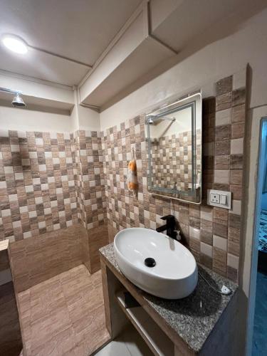 a bathroom with a white sink and a shower at Harry's Homestay in Shillong