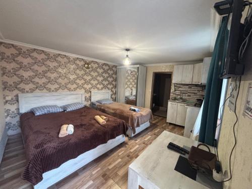 a bedroom with two beds and a table at Guesthouse Saba in Borjomi