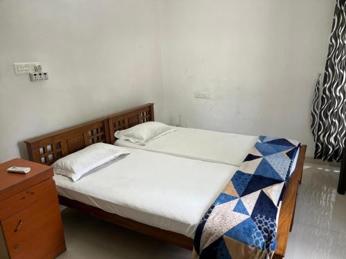 a bedroom with a bed with a wooden frame and a table at THEStay in Alwaye
