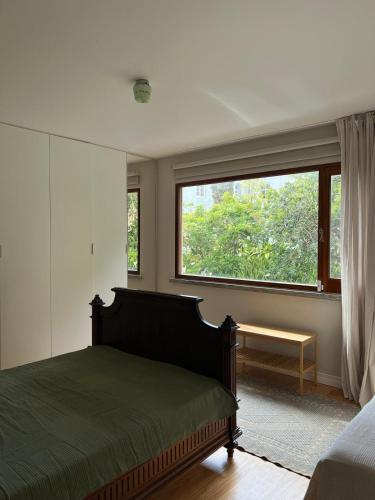 a bedroom with a bed and a large window at Termo Cottage in Lagoa