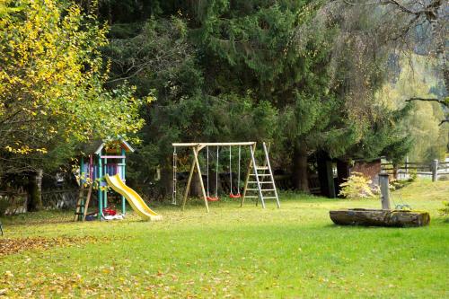 a playground with a slide and a swing set in a park at Ferienhaus Nationalpark in Neukirchen am Großvenediger