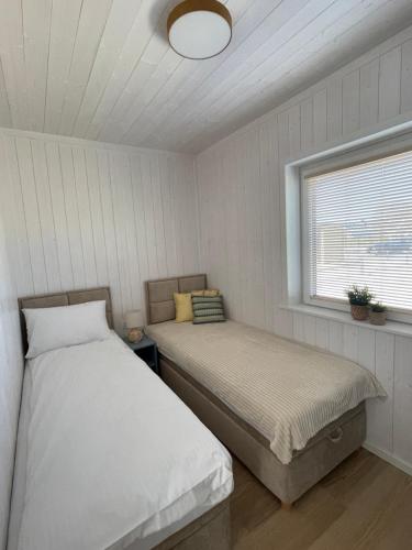 a bedroom with two beds and a window at Aura Baltic in Rewal
