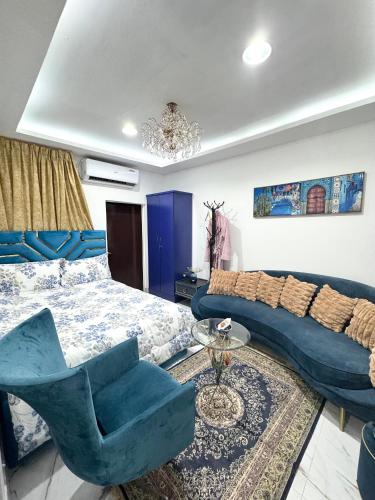 a bedroom with a bed and a couch and a chair at Velmora Villas room 14 in Abu Dhabi