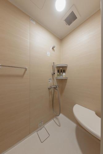 a bathroom with a shower stall and a toilet at Tenjin 旅音 in Kanazawa