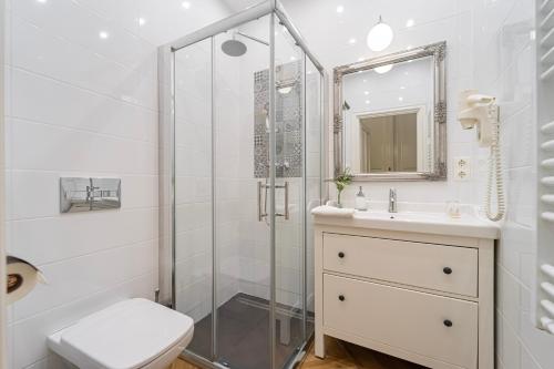 a bathroom with a shower and a toilet and a sink at Serenity Boutique Budapest in Budapest