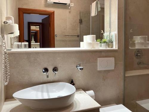 a bathroom with a large white sink and a mirror at Apartments Majda in Lokva Rogoznica