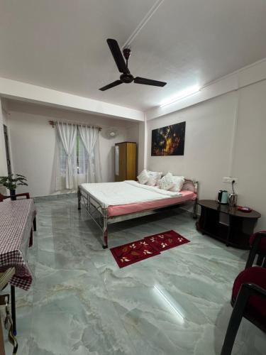 a bedroom with a bed and a ceiling fan at Living Roots Lodge in Cherrapunji