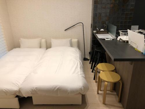 a bedroom with a bed and a desk with a laptop at リブレ芳斉 #102 in Housai