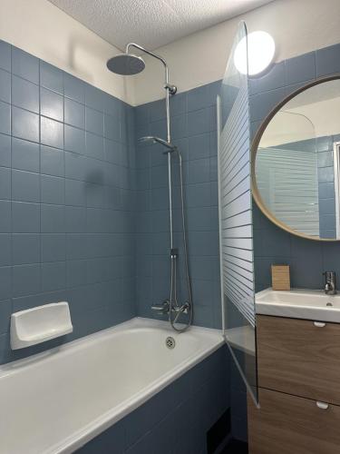 a bathroom with a tub and a sink and a mirror at CHATA u BABULŮ in Morávka