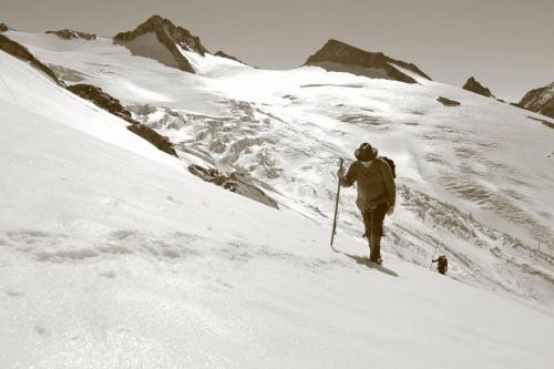 a man is skiing up a snow covered mountain at Ferienhaus Nationalpark in Neukirchen am Großvenediger
