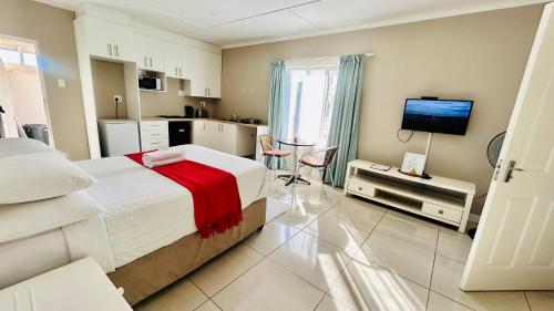 a large bedroom with a bed and a kitchen at Hidden Bliss Guesthouse in East London