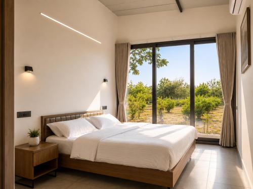 a bedroom with a large bed and a large window at Amrutiya Farm in Bhuj