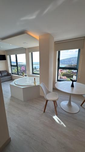 a bathroom with a tub and a table and a chair at O NAUTICO suites in Cabana de Bergantiños