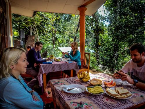 a group of people sitting at a table eating food at Top Heaven in Ella