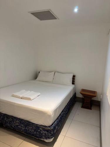a bedroom with a bed with white sheets and pillows at island payless private room in Nadi