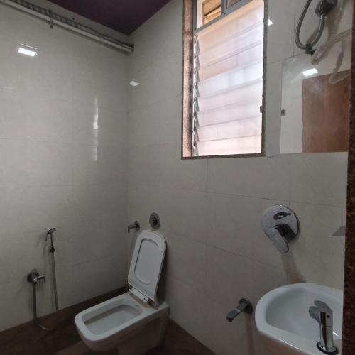 a bathroom with a toilet and a sink at Ruby Lodging And Boarding in Mangrul