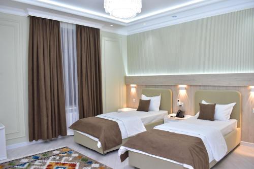 a hotel room with two beds and a chandelier at Veranda XF Hotel in Samarkand