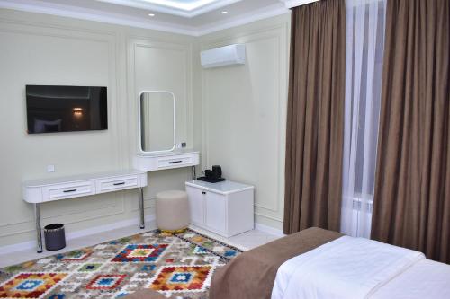 a hotel room with a bed and a tv at Veranda XF Hotel in Samarkand