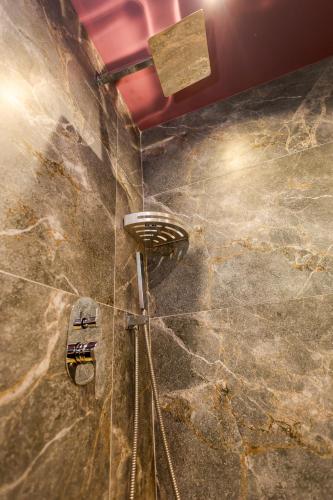 a bathroom with a shower with a stone wall at Sinja Park Villas in Sinjë