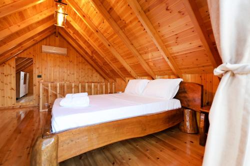a bedroom in a log cabin with a bed at Sinja Park Villas in Sinjë