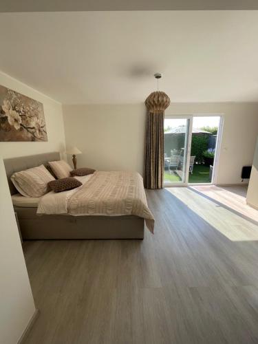 a bedroom with a bed and a sliding glass door at Vakantie Studio Mari Jani in Waterlandkerkje