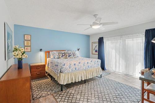 a bedroom with a bed and a blue wall at Land's End 8-301 Beach Front in St. Pete Beach