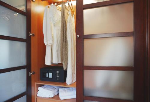 a closet with a door with a microwave and towels at Nereids Apartments in Sitia