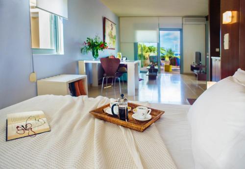 a hotel room with a bed with a tray of food at Nereids Apartments in Sitia