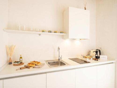 a kitchen with white cabinets and a sink at Palazzo Della Tore 001-Elegant Historic Escape in Torre a Mare