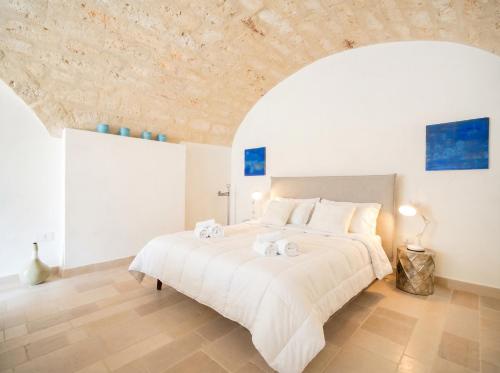 a bedroom with a large white bed with towels on it at Palazzo Della Tore 001-Elegant Historic Escape in Torre a Mare